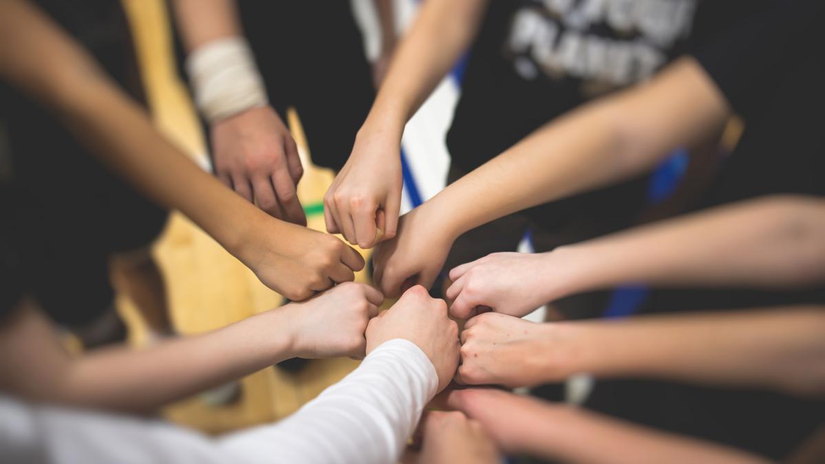 Close up of high school student fist bump in a circle before a game