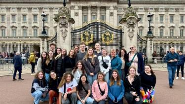 A group of students pose together in front of Buckingham Palace