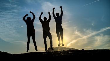 Youth jumping in silhouette against a setting or rising sun